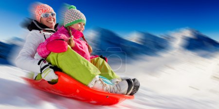 Winter fun, snow, family sledding at winter time