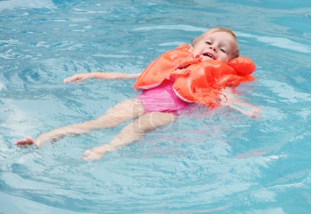 Little child in the life jacket floating. Insurance concept.