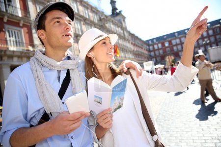 Tourists walking in La Plaza Mayor with traveler guide