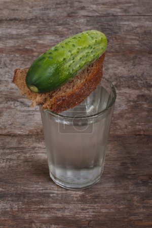 Vodka, bread and cucumber on the table. Russian snack
