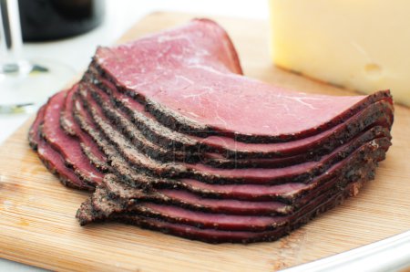 Deli pastrami meat sliced on cutting board