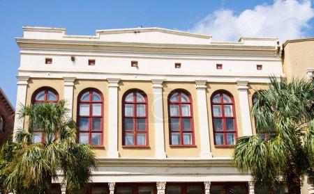 Red Arched Windows on Tropical Stucco Building