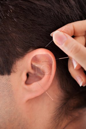 Person Holding Needle Near Ear