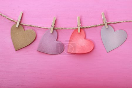 Paper hearts hanging from string with clothespins