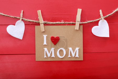 Mothers day message with clothespins over red wooden board 
