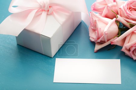 Blank message card with gift box and roses