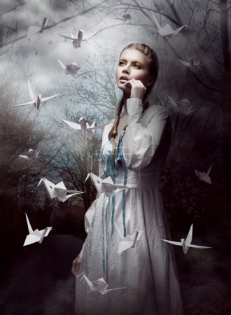 Night. Woman in Mysterious Forest launching handmade paper Cranes. Origami