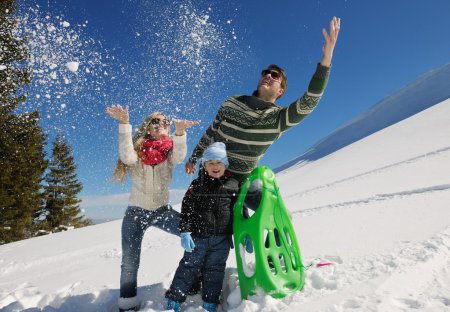 Family having fun on fresh snow at winter vacation