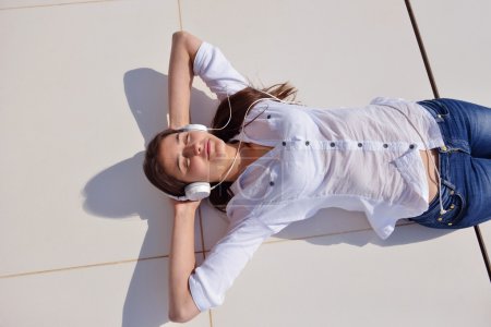 Girl listening music on white headphones