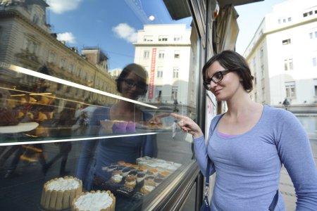 woman in front of sweet store window