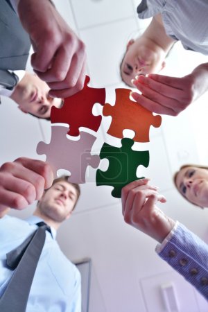 Group of business assembling jigsaw puzzle