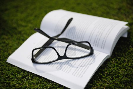 Glasses on a book outside with grass
