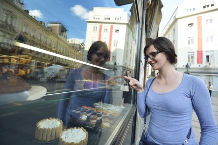 woman in front of sweet store window
