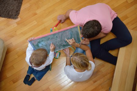 family drawing on school board at home