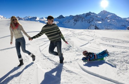 Family having fun on fresh snow at winter vacation