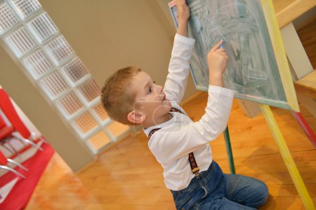 Boy drawing on school board at home