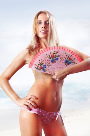 woman holding fan on beach