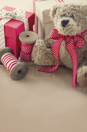 Vintage ribbons spools and gift boxes and and old teddy bear
