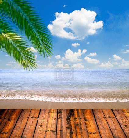 Tropical sea and beach with palm leaves and wooden floor