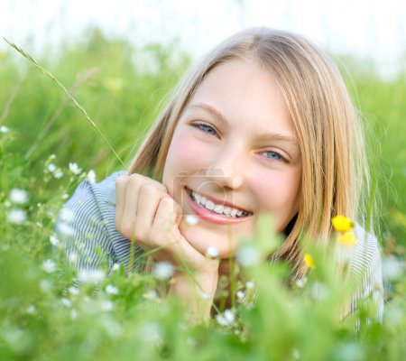Smiling Girl Relaxing outdoors. Meadow