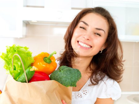 Happy Young Woman with vegetables in shopping bag. Diet Concept