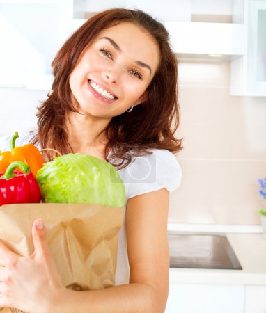 Happy Young Woman with vegetables in shopping bag. Diet Concept