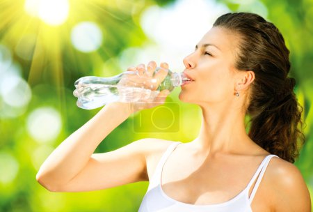 Healthy and Sporty Young Woman Drinking Water from the Bottle