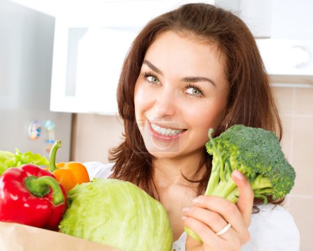 Happy Young Woman with vegetables in shopping bag