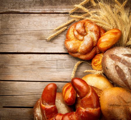 Bakery Bread and Sheaf over Wood Background