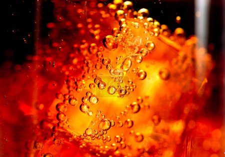Cola with ice and bubbles in glass