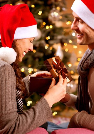Christmas Scene. Happy Couple with Christmas Gift at Home