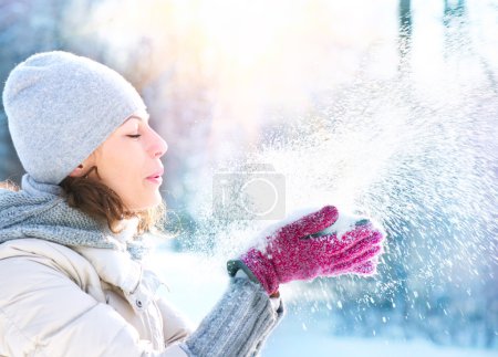 Beautiful Winter Woman Blowing Snow outdoor