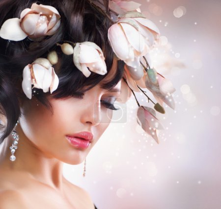 Fashion Brunette Girl with Magnolia. Hairstyle