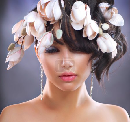 Fashion Brunette Girl with Magnolia Flowers. Hairstyle