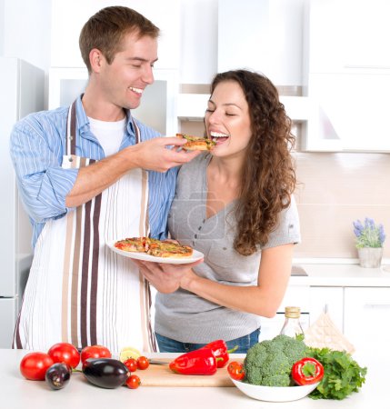 Happy Couple Eating Pizza. Cooking Together