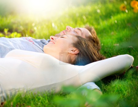Young Couple Lying on Grass Outdoor