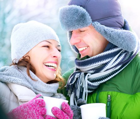 Happy Couple with Hot Drinks Outdoors. Winter Vacation