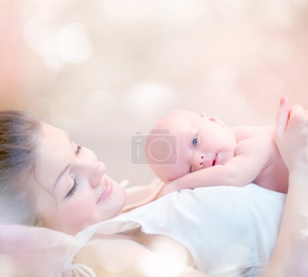 Happy Mother and her Newborn Baby Kissing and hugging