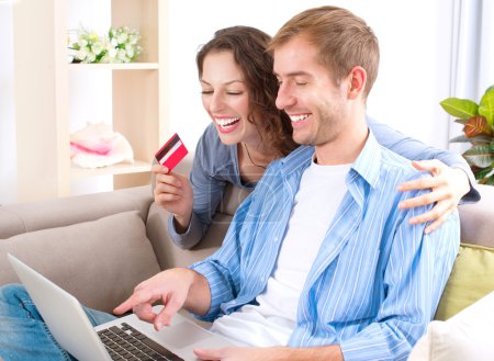 Young couple with Laptop and Credit Card buying online