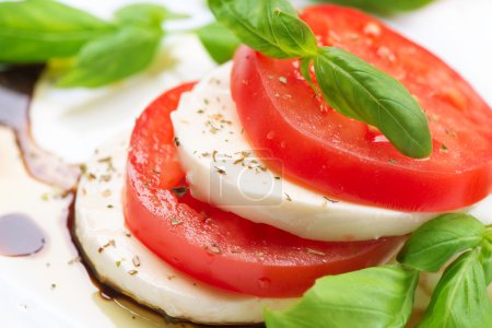 Caprese Salad. Tomato and Mozzarella slices with basil leaves