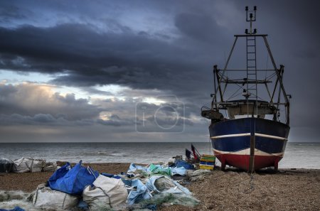 Fishing boat on beach landscape with stormy sky