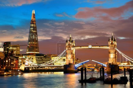The Shard and Tower Bridge over Thames River in London at dusk.