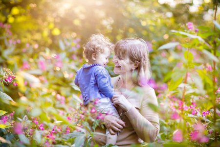 Woman playing with a happy baby girl in a garden