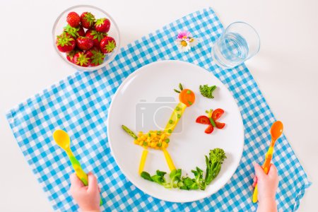 Child's hand and healthy vegetable lunch