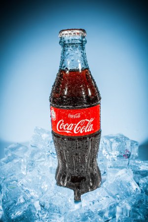 Bottle of Coca-Cola on ice.