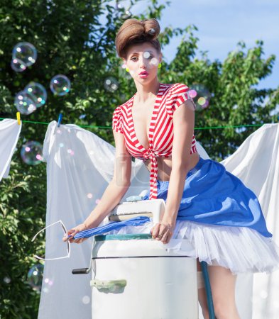 Woman with vintage wringer washing machine