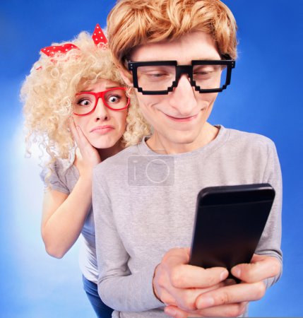 Girl is spying on boyfriend he is using a smart phone