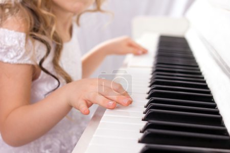 Little girl playing on piano