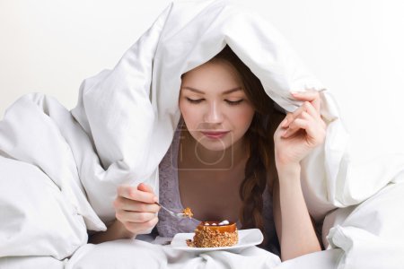 girl eating cake under cover