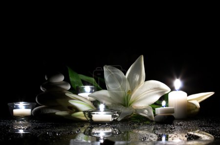 white lily, stones and candles